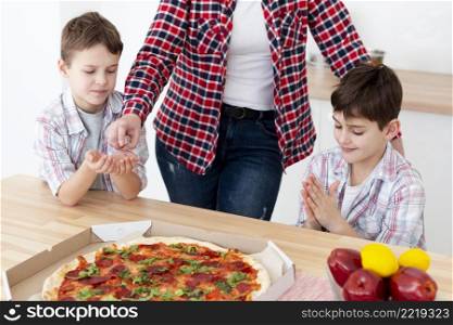 high angle kinds sanitizing their hands before eating pizza