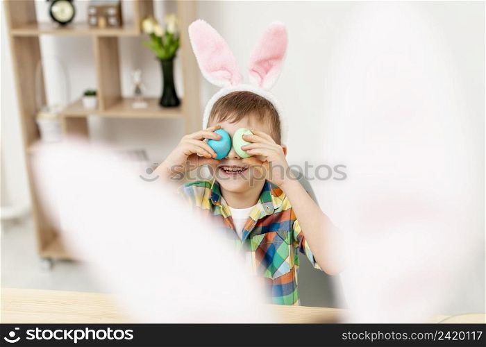 high angle little boy playing with eggs