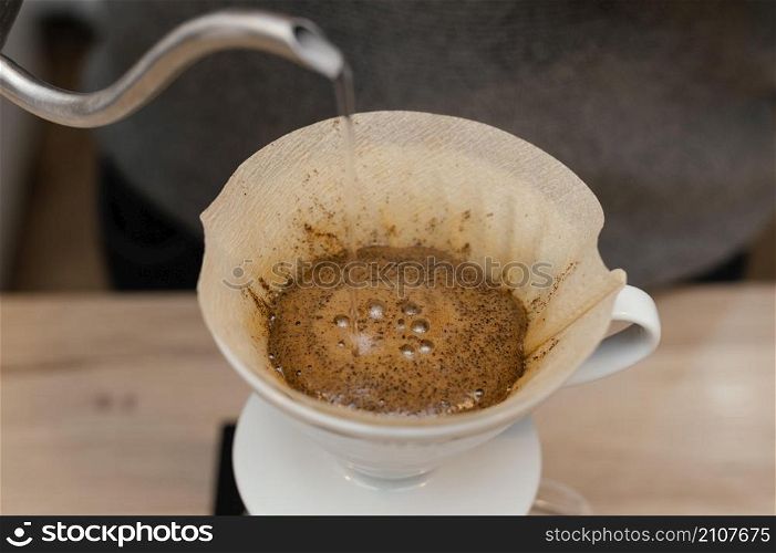 high angle male barista pouring hot water coffee filter
