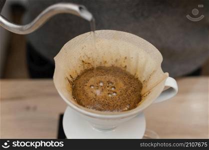 high angle male barista pouring hot water coffee filter