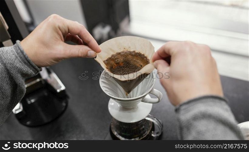 high angle male barista taking off coffee filter