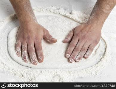 high angle man kneading pizza dough