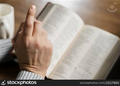 high angle man reading bible pointing finger