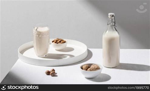 high angle milk bottle with glass tray walnuts