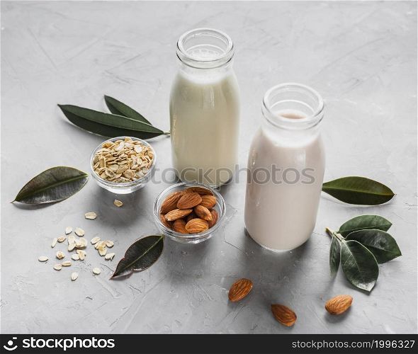 high angle milk bottles with almonds oats