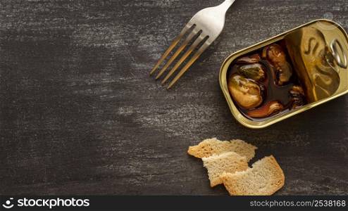 high angle mussels tin can with toast fork with copy space