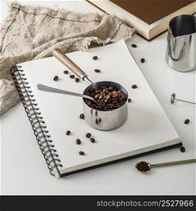 high angle notebook with cup roasted coffee beans