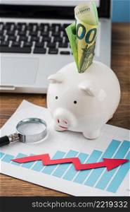high angle office items with piggy bank growth chart