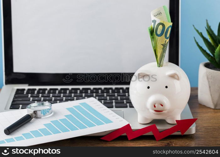 high angle office items with piggy bank laptop