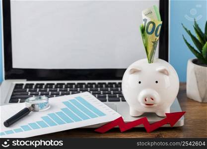 high angle office items with piggy bank laptop