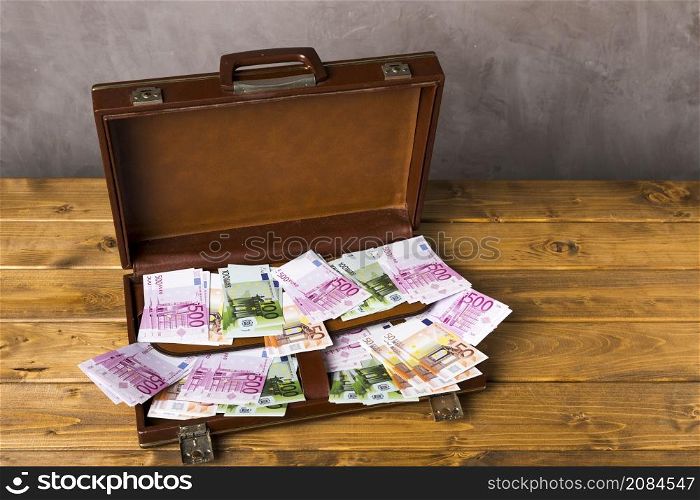 high angle opened suitcase with money