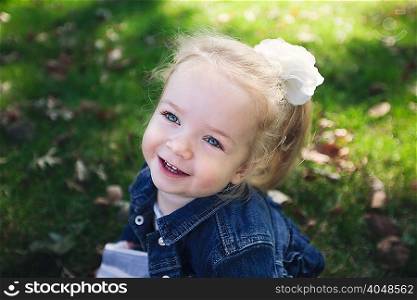 High angle portrait of girl with white flower hair accessory wearing denim jacket looking away smiling