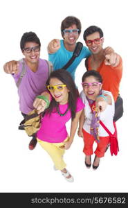 High angle portrait of university students wearing glasses while pointing at you over white background