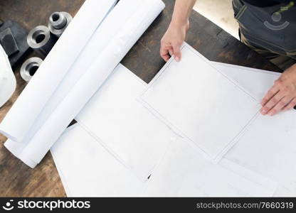 High angle shot of engineer looking on blueprints