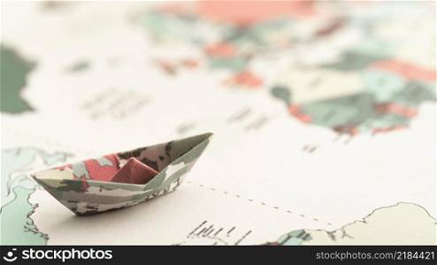 high angle small origami boat world map