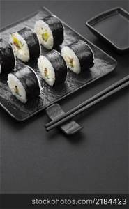 high angle sushi rolls with chopsticks sauce