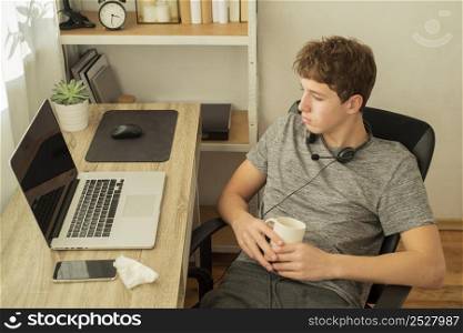 high angle teenager boy doing online classes