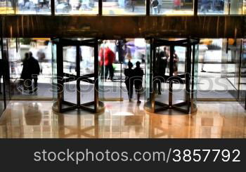High angle time lapse of people passing through revolving doors of a city building