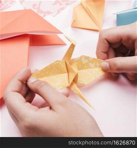 high angle view artist hand holding origami paper bird