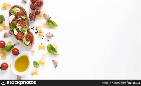 high angle view bruschetta farfalle raw pasta garlic clove tomato oil basil leaf against isolated white background. High resolution photo. high angle view bruschetta farfalle raw pasta garlic clove tomato oil basil leaf against isolated white background. High quality photo