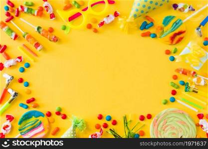 high angle view candies lollipops candles party blower yellow surface. High resolution photo. high angle view candies lollipops candles party blower yellow surface. High quality photo