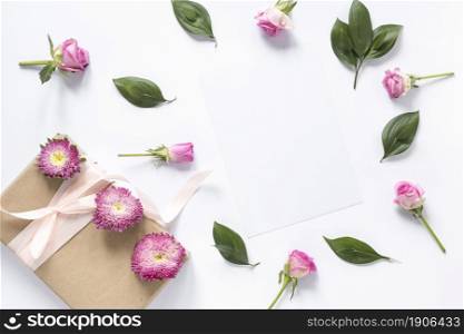 high angle view flowers leaves with gift box white surface. High resolution photo. high angle view flowers leaves with gift box white surface. High quality photo