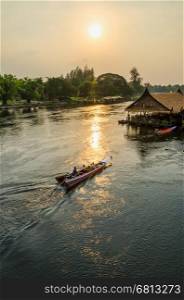 High angle view from bridge, beautiful landscape of Kwai Yai River at sunset and lifestyle of people on the waterfront in Kanchanaburi Province, Thailand