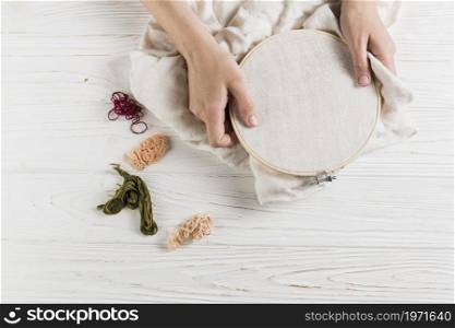 high angle view hand holding hoop colorful thread white wooden table. High resolution photo. high angle view hand holding hoop colorful thread white wooden table. High quality photo