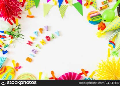 high angle view happy birthday text with party accessories white backdrop
