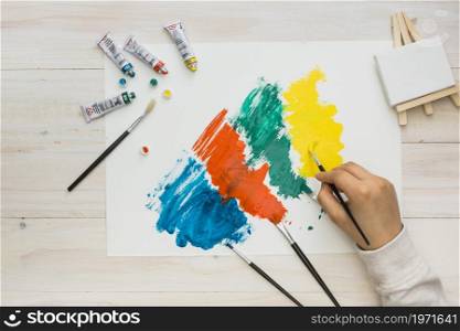 high angle view human hand painting white paper colorful brushstroke. High resolution photo. high angle view human hand painting white paper colorful brushstroke. High quality photo
