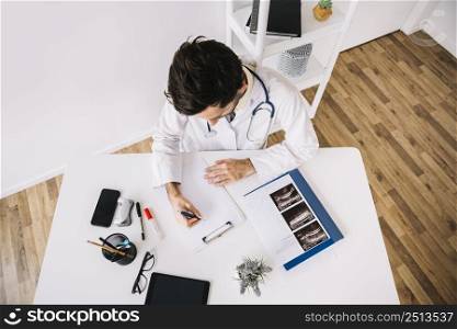 high angle view male doctor writing clipboard clinic