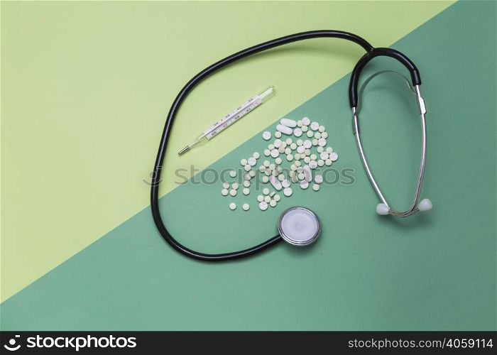 high angle view medicines thermometer stethoscope dual colored background