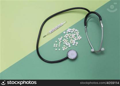 high angle view medicines thermometer stethoscope dual colored background