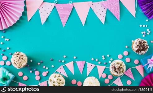 high angle view muffins with party accessories green surface. Resolution and high quality beautiful photo. high angle view muffins with party accessories green surface. High quality beautiful photo concept
