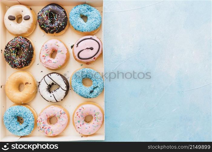 high angle view multi colored fresh donuts box blue background