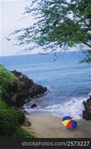 High angle view of a beach umbrella and rocks on the beach, Hawaii, USA
