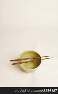 High angle view of a bowl and two chopsticks