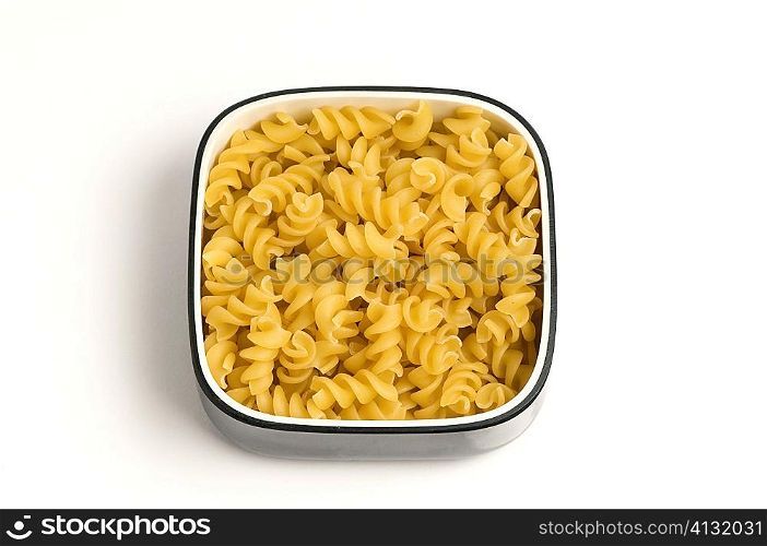 High angle view of a bowl of raw fusilli pasta