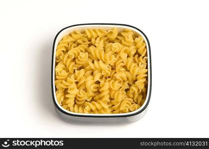 High angle view of a bowl of raw fusilli pasta