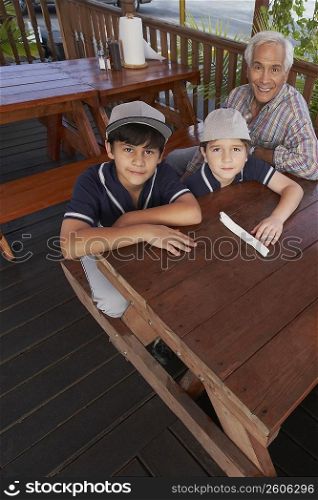 High angle view of a boy and a girl sitting with their grandfather in a restaurant