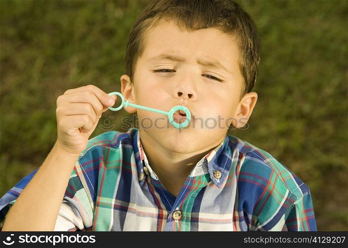 High angle view of a boy blowing bubbles with a bubble wand