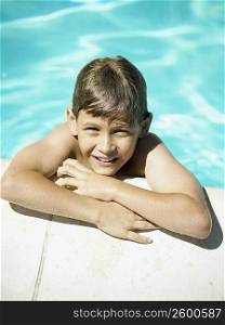 High angle view of a boy leaning at the edge of a swimming pool