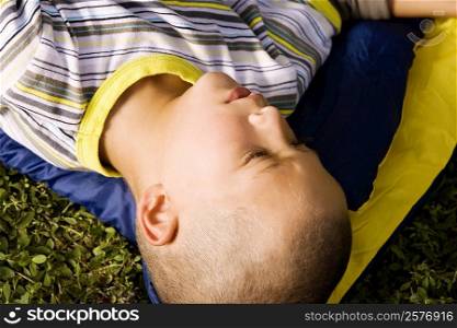 High angle view of a boy lying on a sleeping bag