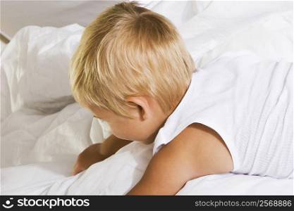 High angle view of a boy lying on the bed