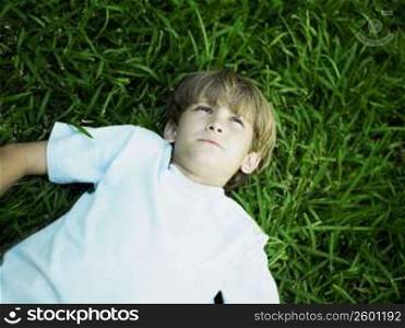High angle view of a boy lying on the grass