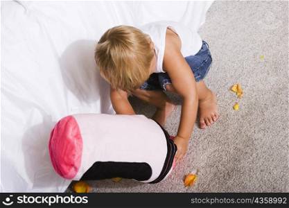 High angle view of a boy playing with a cushion