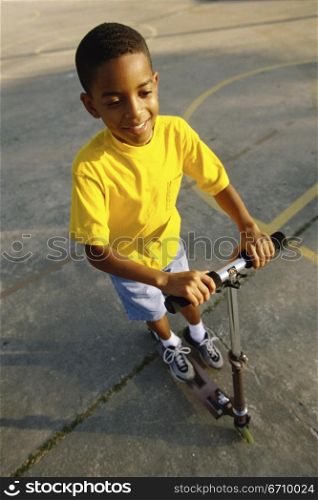 High angle view of a boy playing with a scooter