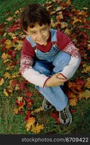 High angle view of a boy sitting on a lawn looking up