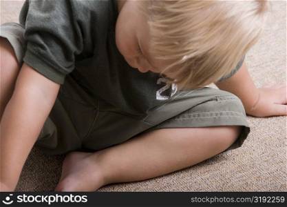 High angle view of a boy sitting on the floor
