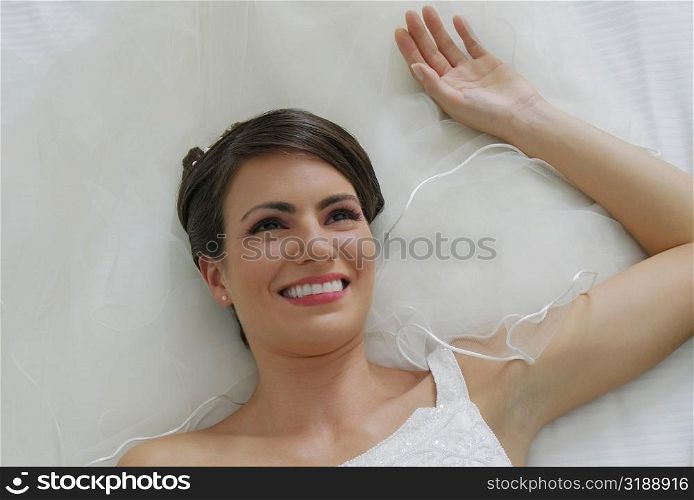 High angle view of a bride lying on the bed and smiling